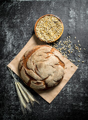 Wall Mural - Fragrant bread on paper with grains and spikelets.