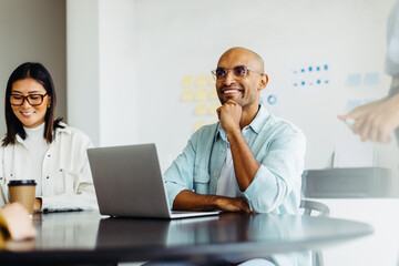 Poster - Business man listening to a discussion during a meeting with his team