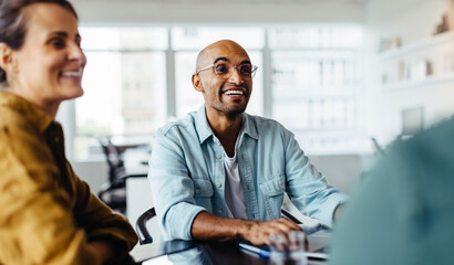Poster - Business man sitting in a meeting with his team