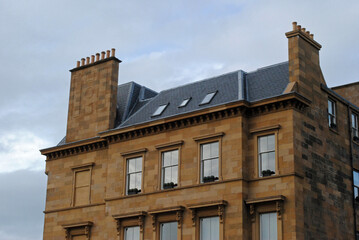 Wall Mural - Facade of 19th Century Stone House with Chimneys against Cloudy Sky