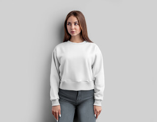 Poster - Mockup of a white female sweatshirt, a shirt on a girl in gray jeans, isolated on a background, front.