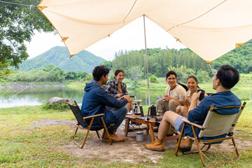 Group of Asian Man and woman friends having breakfast and making brewed coffee at camp in the morning. People enjoy and fun outdoor lifestyle travel nature and camping together on summer vacation.