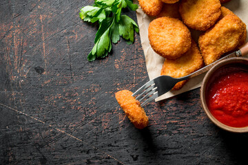 Poster - Chicken nuggets on paper and fork with sauce and parsley.