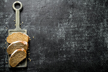 Poster - Pieces of bread with grains on the cutting Board.