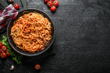 Canvas Print - Spaghetti with Bolognese sauce in pan with napkin, tomatoes and garlic.