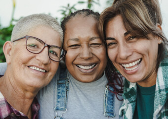 Wall Mural - Happy multiracial senior women having fun together outdoor - Elderly generation people hugging each other