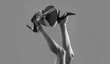 © Yevhen - High heel shoes. Gift in heart shape on the background. Shapely legs, a girl in shoes high-heeled. Female legs wearing high heels. Black and white