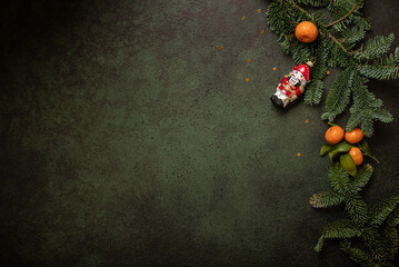  Christmas composition with nobilis, nutcracker and tangerines on a dark green background. New Year is near