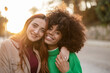 © PintoArt - portrait of two multiracial women together, lesbian couple, at sunset