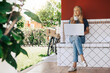 © Jordi - Young blond woman working from home while talking on the phone.
