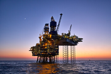 offshore oil and gas platform in the sea at sunset. jack up rig crude oil production in ocean.