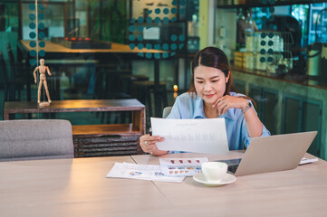 Wall Mural - Asian business woman working using  laptop for do math finance on wooden desk, tax, accounting, statistics and analytical research concept