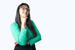 © Pajaros Volando - Businesswoman wearing eyeglasses thinking over isolated white background and smiling at camera. Looking up at copy space