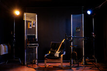 Empty Music Recording Studio With Guitar On Chair, Next To Amps, Sound Amplifier Equipment. Nobody In Professional Dark Rock Room, Performance Speaker
