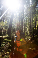 Sun Rays Fill The Frame As A Young Woman Takes A Break From Backpacking On A Sunny Afternoon.
