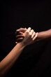 © Cavan Images - Male and female hands with different skin tones holding each other