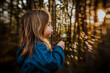 © Cavan Images - Girl blowing a dandelion at golden hour on a spring evening