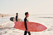 young latino surfers entering the water to surf in La Serena