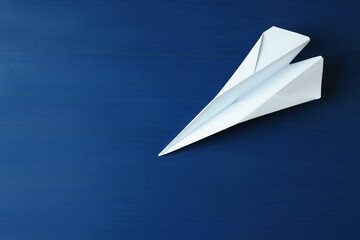 Wall Mural - Handmade paper plane on blue wooden table. Space for text