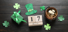 Calendar With Date MARCH, 17, Symbols Of St. Patrick's Day And Gift On Wooden Background