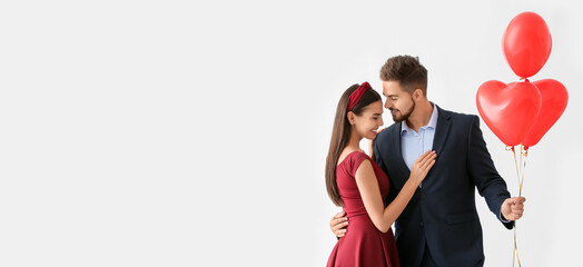 Canvas Print - Portrait of happy young couple with balloons on white background with space for text. Valentine's Day