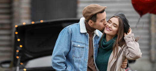 Canvas Print - Happy young man kissing his girlfriend near car outdoors. Valentine's Day celebration