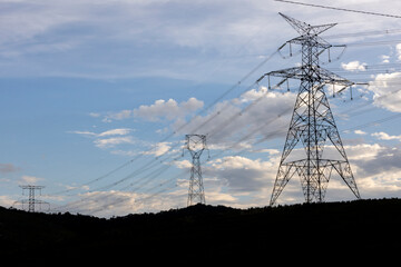 Silhouette of electric power towers during dusk in countryside of Brazil