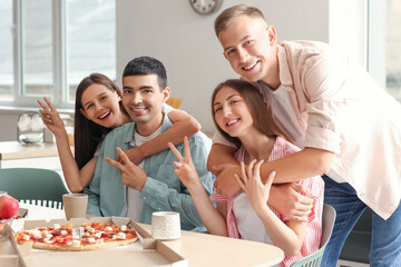 Wall Mural - Group of friends showing victory gesture in kitchen