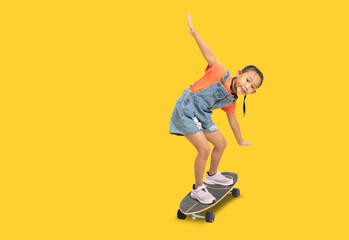 Happy asian little girl playing skateboard, Full body portrait isolate on yellow background with clipping path for design work