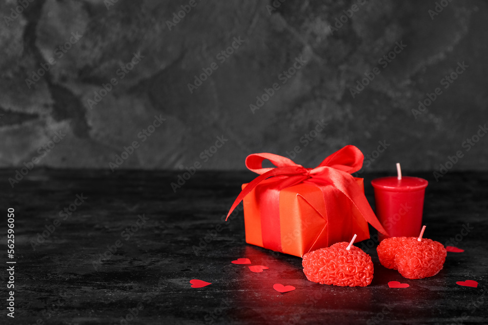 Beautiful candles, gift box and paper decor on dark background. Valentine's Day celebration