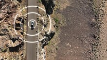 Overhead Aerial Shot Of A Self Driving Truck Navigating A Steep Desert Cliff Roadway.