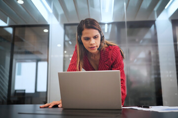 Cheerful attractive young businesswoman having online business meeting on laptop