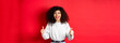 Enthusiastic girl with curly hair and red lips, showing thumbs up and saying yes, agree with you, compliment good work, like something cool, standing on studio background