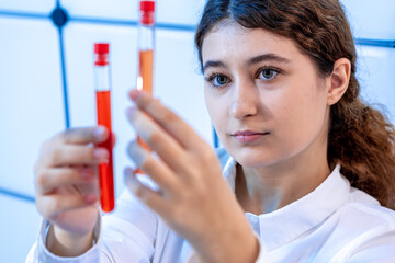 Sticker - girl laboratory assistant compares the contents of two test tubes in a chemical laboratory