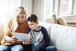 © Grady R/peopleimages.com - Tablet, love and mother with boy on sofa bonding, quality time and relax on weekend together. Family home, lifestyle and mom and kid with digital tech for online games, social media and internet app