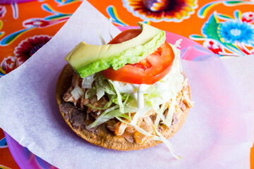 Wall Mural - Tostada with salad and avocado. Tostada, name given to various dishes in Mexico that include a toasted tortilla as the main base of its preparation.