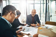 © Grady R/peopleimages.com - Corporate, man and leader with team, meeting and brainstorming in office, planning schedule and marketing campaign. Team, manager and staff in workplace, sales growth and teamwork for advertising