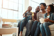 © Grady R/peopleimages.com - Happy black family on sofa for movie, television or film together, bonding and quality time in living room. Popcorn, kids TV show and people, mother and father with kids, sitting on couch watching