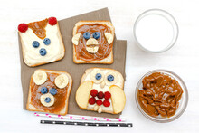 Funny Cute Bear,monkey,fox,owl Faces Sandwich Toast Bread With Peanut Butter,banana,blueberry,raspberry,milk. Kids Childrens Baby's Sweet Dessert Healthy Breakfast Lunch Food Art,close Up,top View.