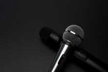Black And Silver Modern Microphones On Black Slate. Microphones Depict The Letter "X".