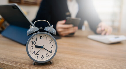 Wall Mural - alarm clock on the desk. business working in modern office building or home at night using laptop..