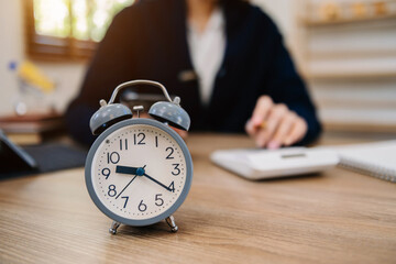 Wall Mural - alarm clock on the desk. business working in modern office building or home at night using laptop..