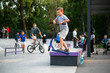 boy exercising on a scooter in a skatepark