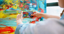 Close Up Of Caucasian Young Happy Woman Artist Taking Photos Of Finished Colorful Abstract Artwork On Large Canvas On Smartphone In Art Studio Pretty Painter Looking At Camera And Smiling, Art Concept