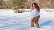 © Михаил Решетников - A fat red-haired woman in a white sweatshirt walks through snowdrifts.