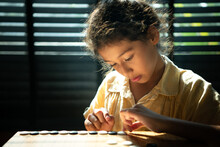 Portrait Of A Little Girl In Office Room Of House With A Game Of Go Being Learned To Build Concentration And Intelligence.