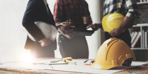 Wall Mural - Civil engineer teams meeting working together wear worker helmets hardhat on construction site in modern city. Foreman industry project manager engineer teamwork. Asian industry professional team.