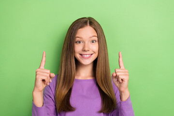 Poster - Photo of adorable lovely cheerful lady wear stylish purple jumper demonstrate empty space isolated on green color background