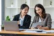 © crizzystudio - Business idea creative brainstorming sessions for projects Strategic topic of two Asian girls working together data analysis Happy clarification of various financial information at the desk.