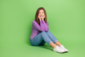 Sticker - Full length photo of good mood girl with straight hairdo wear purple pullover sitting look empty space isolated on green color background